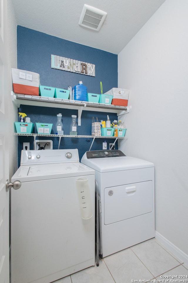 laundry room featuring light tile patterned flooring and washer and clothes dryer