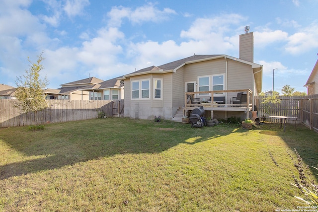 back of house featuring a wooden deck and a lawn