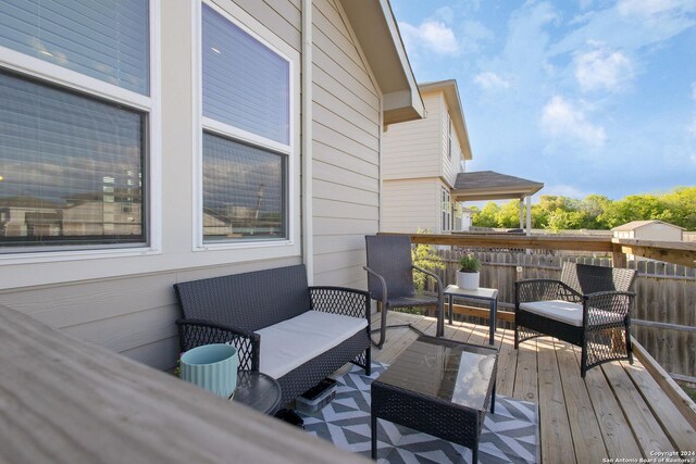 wooden terrace with an outdoor living space