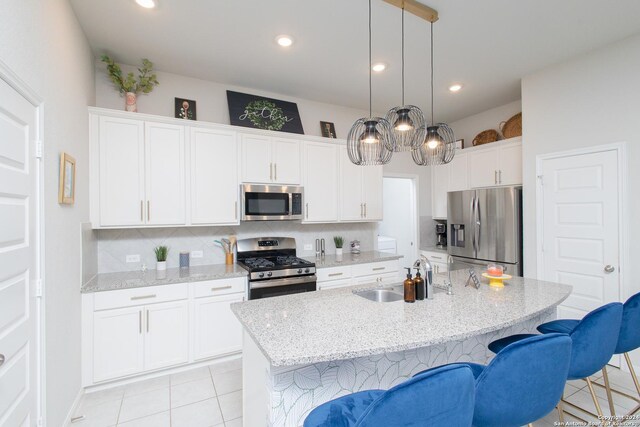 kitchen with white cabinets, decorative backsplash, sink, appliances with stainless steel finishes, and light tile patterned floors