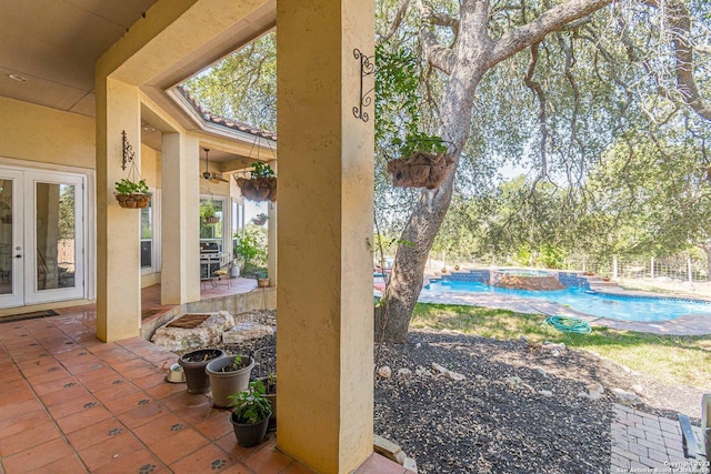 view of patio featuring french doors and a swimming pool with hot tub