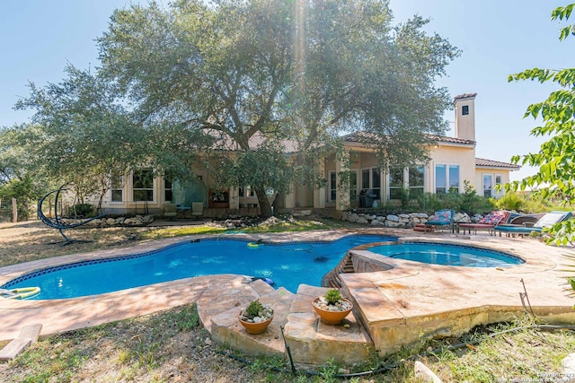 view of pool featuring an in ground hot tub