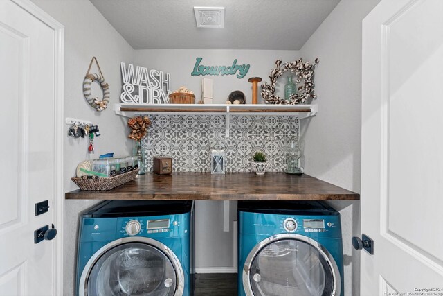 washroom featuring bar, washer and dryer, and a textured ceiling