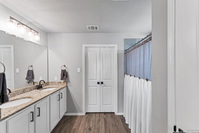 bathroom featuring vanity, hardwood / wood-style floors, a textured ceiling, and a shower with curtain