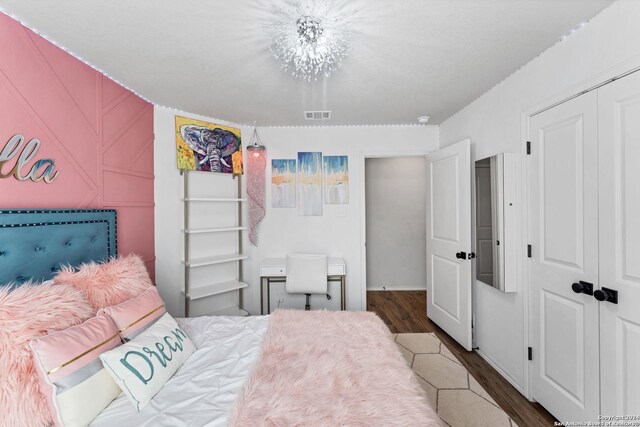 bedroom with dark wood-type flooring and a closet