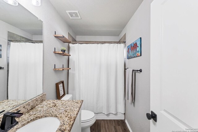 bathroom featuring a shower with curtain, wood-type flooring, vanity, and toilet