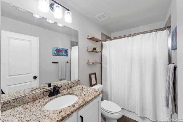 bathroom with vanity, a shower with shower curtain, and toilet