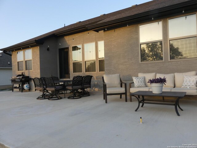 back of house featuring an outdoor living space and a patio