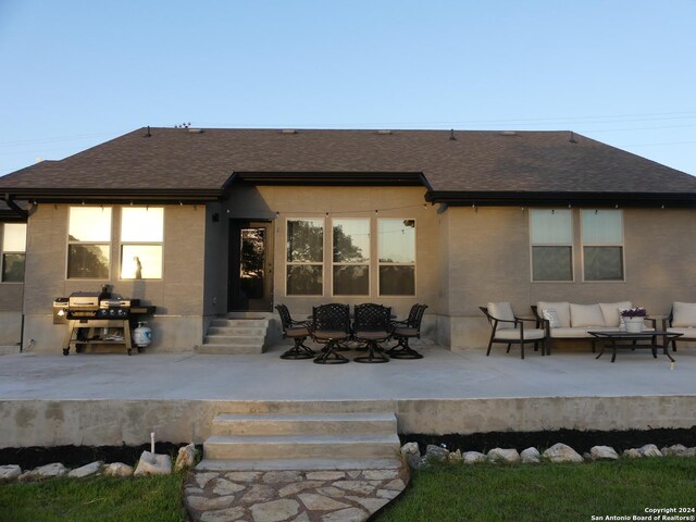 rear view of property featuring an outdoor living space and a patio