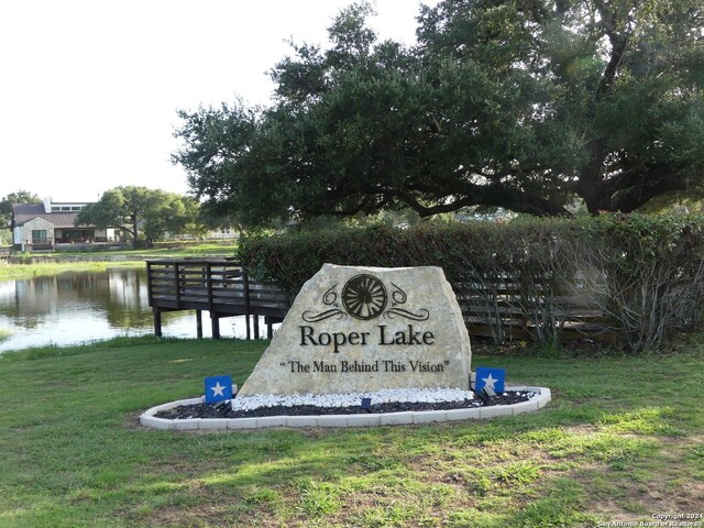 community sign with a yard and a water view