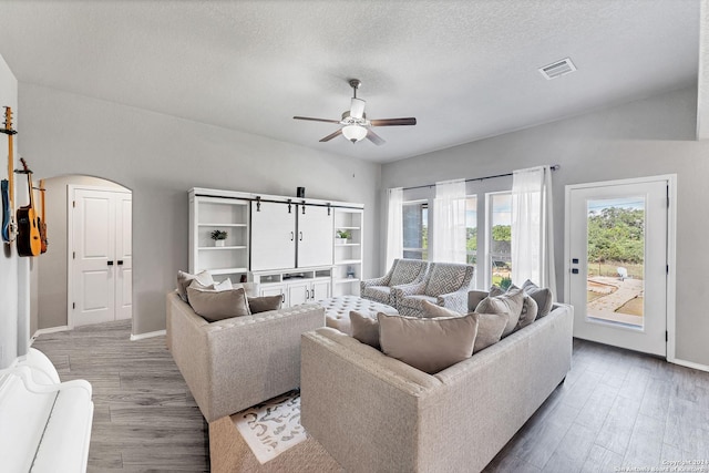 living room featuring ceiling fan, hardwood / wood-style floors, and a textured ceiling