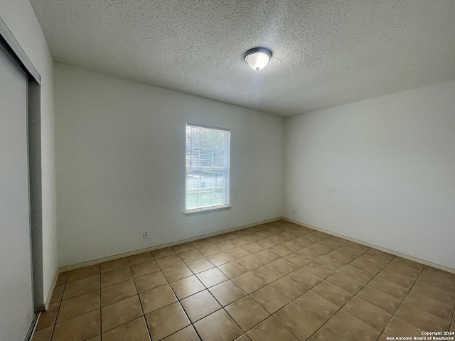 unfurnished room with a textured ceiling