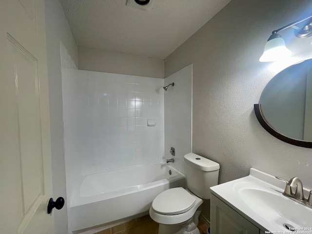 full bathroom featuring vanity, tiled shower / bath, a textured ceiling, and toilet