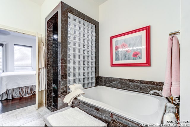 bathroom featuring a relaxing tiled tub