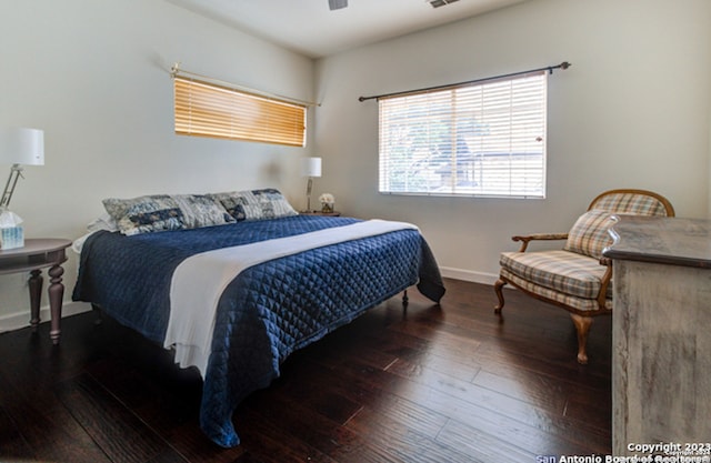 bedroom with dark hardwood / wood-style flooring and ceiling fan