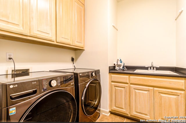 laundry area with washer and dryer, sink, light tile patterned floors, and cabinets