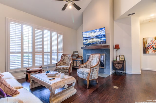 living room with ceiling fan, dark hardwood / wood-style floors, high vaulted ceiling, and a tile fireplace