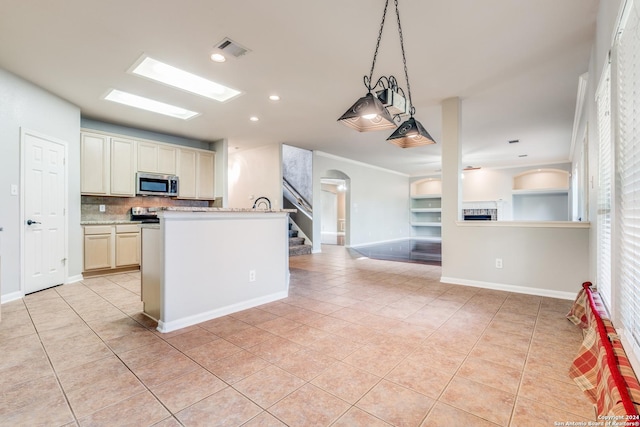 kitchen featuring light stone counters, light tile patterned flooring, decorative backsplash, decorative light fixtures, and cream cabinetry