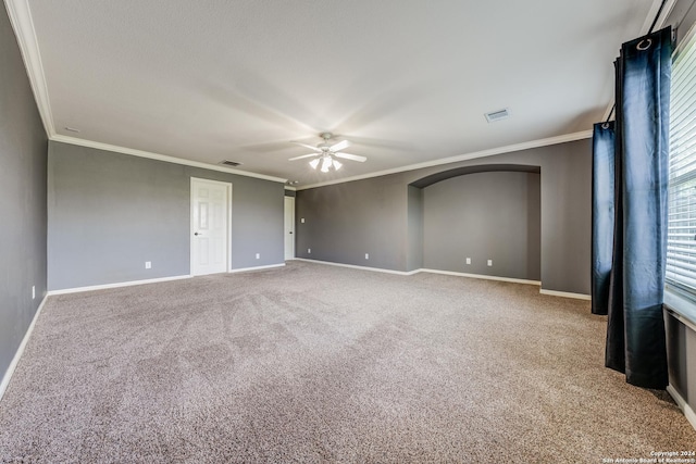 empty room featuring crown molding, carpet flooring, and ceiling fan