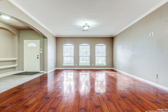 entryway with ornamental molding and hardwood / wood-style floors