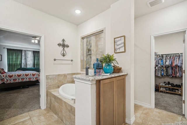 bathroom featuring a relaxing tiled tub and tile patterned floors