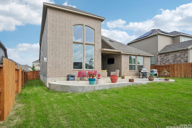 back of property featuring a patio area and a lawn