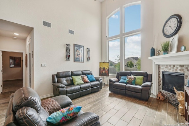 living room featuring a towering ceiling and a brick fireplace