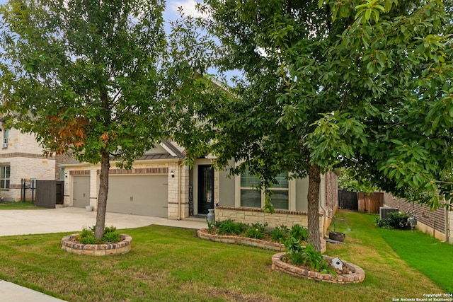 view of property hidden behind natural elements featuring a garage and a front yard