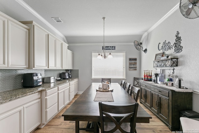 dining room featuring crown molding and light hardwood / wood-style flooring