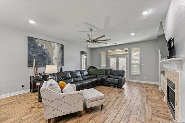 living room with ceiling fan, light hardwood / wood-style floors, and french doors