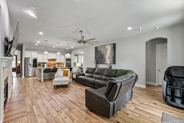 living room with ceiling fan and light wood-type flooring