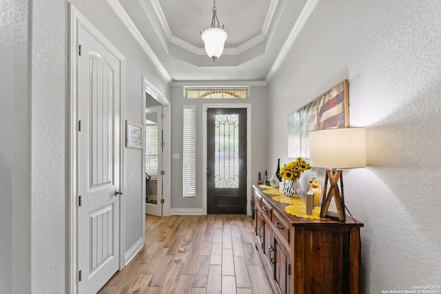 foyer featuring crown molding, a tray ceiling, and light hardwood / wood-style flooring