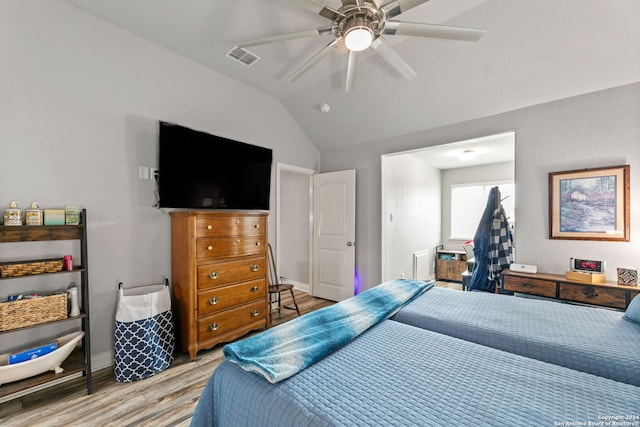 bedroom with ceiling fan, vaulted ceiling, and light hardwood / wood-style flooring