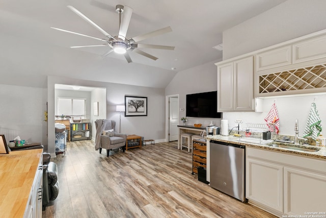 kitchen featuring lofted ceiling, sink, wooden counters, stainless steel dishwasher, and light wood-type flooring