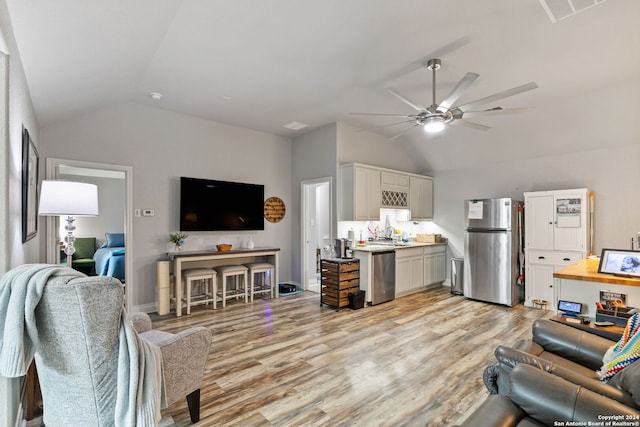 living room with lofted ceiling, sink, light hardwood / wood-style flooring, and ceiling fan