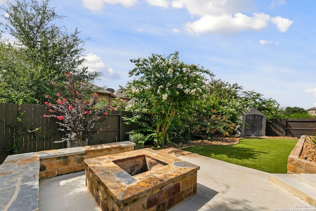 view of patio / terrace with a shed and a fire pit