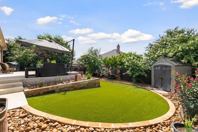 view of yard featuring a storage shed and a patio area