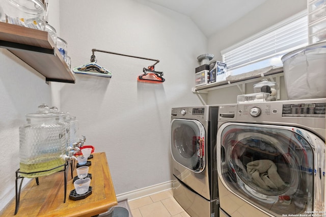 laundry area featuring washing machine and dryer and light tile patterned floors