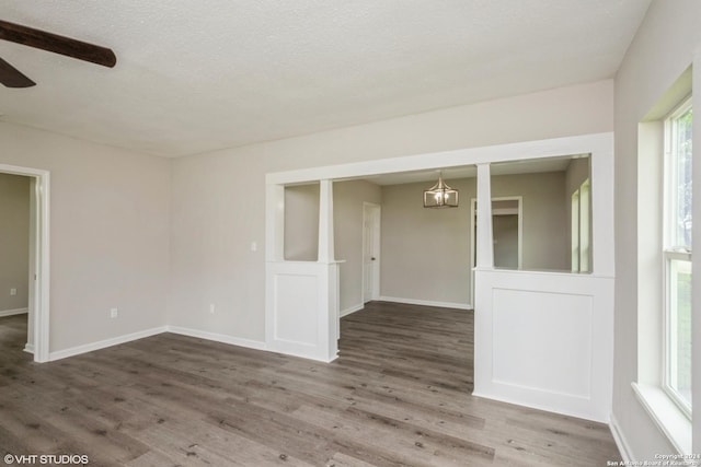 unfurnished room featuring ceiling fan, hardwood / wood-style floors, and a textured ceiling