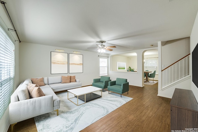 living room with dark wood-type flooring and ceiling fan