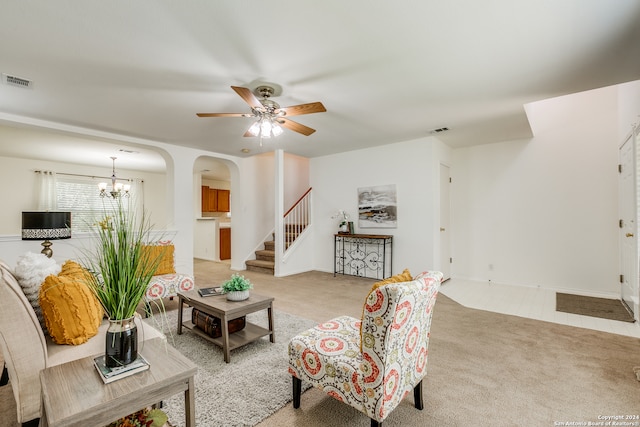 living room with light carpet and ceiling fan with notable chandelier