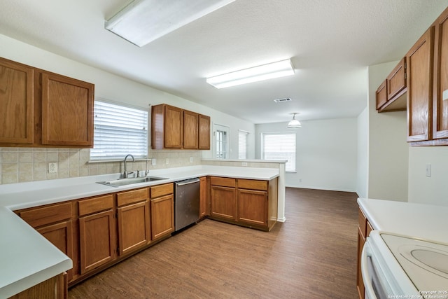 kitchen featuring light hardwood / wood-style floors, stainless steel dishwasher, kitchen peninsula, and sink