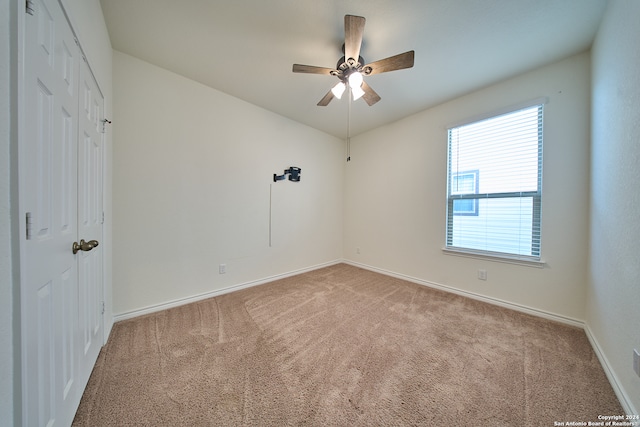 carpeted empty room featuring ceiling fan