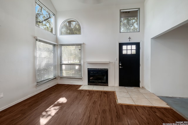 unfurnished living room with a fireplace, a wealth of natural light, and light wood-type flooring