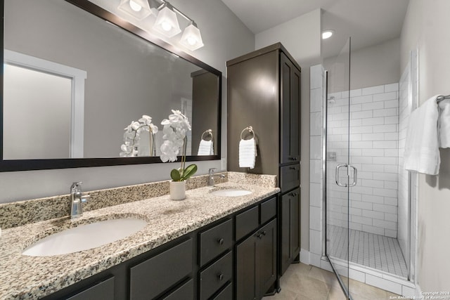 bathroom with double vanity, tile patterned flooring, a shower stall, and a sink