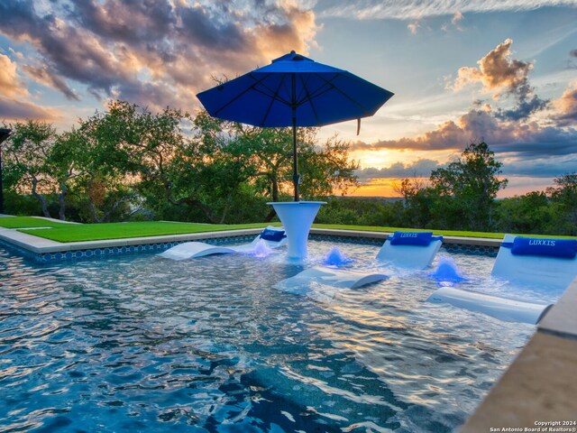 view of pool at dusk