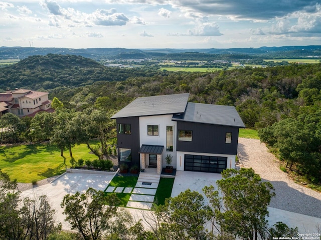 view of front of property featuring a standing seam roof, a mountain view, an attached garage, and metal roof