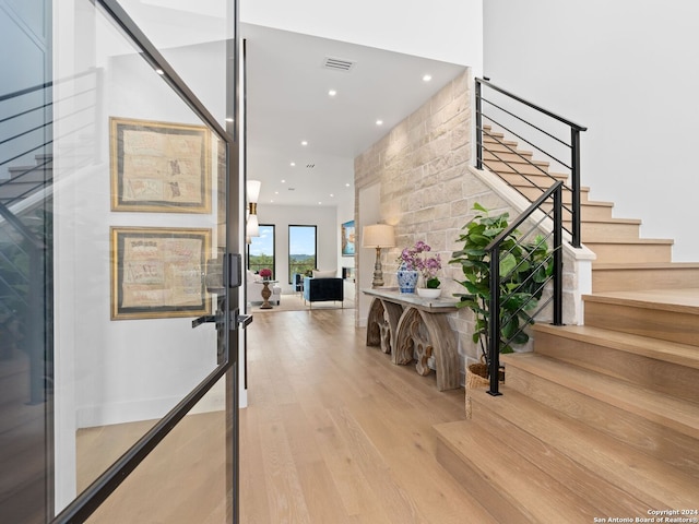 foyer entrance with recessed lighting, visible vents, light wood-style flooring, and stairs