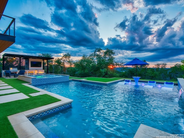 pool at dusk with an outdoor living space, an in ground hot tub, and a lawn