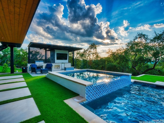 view of swimming pool featuring an outdoor kitchen, a lawn, grilling area, outdoor lounge area, and a patio area